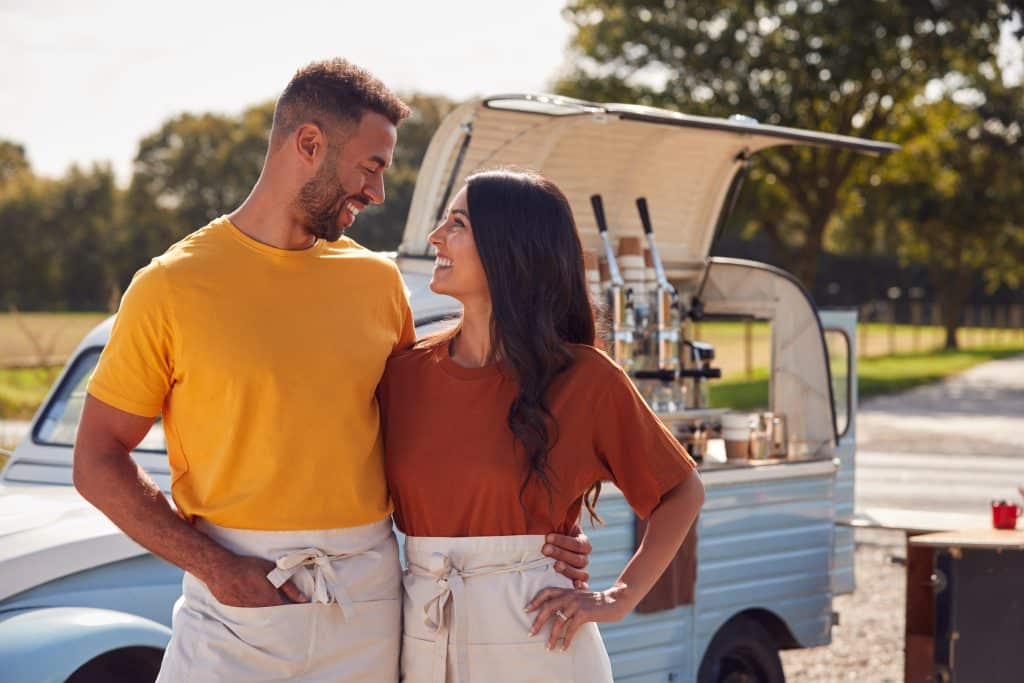 couple standing in front of their mobile coffee truck