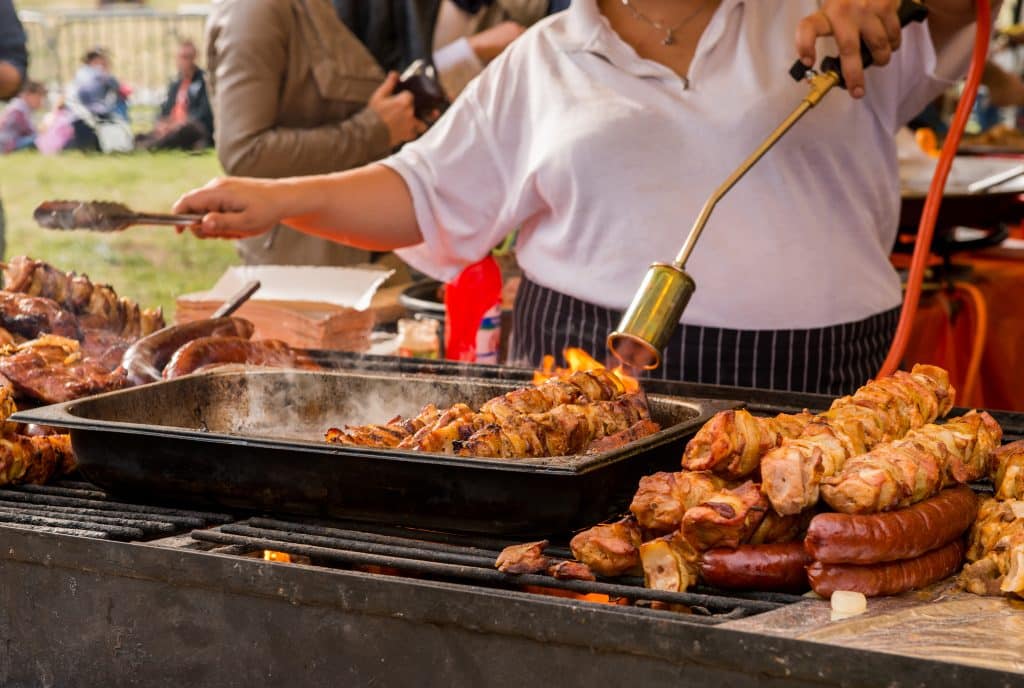 woman grilling meat at outdoor festival